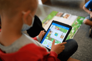 A toddler is playing with an electronic device 
