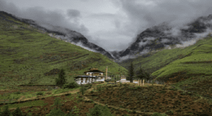 A picturesque monastery nestled in the mountains, with fluffy clouds drifting above, creating a peaceful atmosphere.