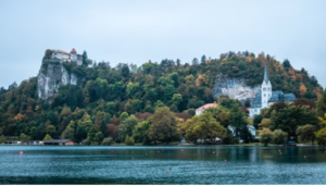 Scenic view of Lake Bled in Slovenia, featuring a church on an island and a castle on a cliff overlooking the water.